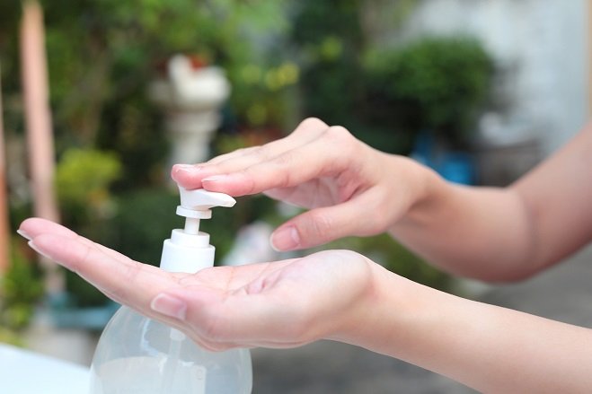 Female Hands Using Gel Pump Dispenser Wash Hand Sanitizer.